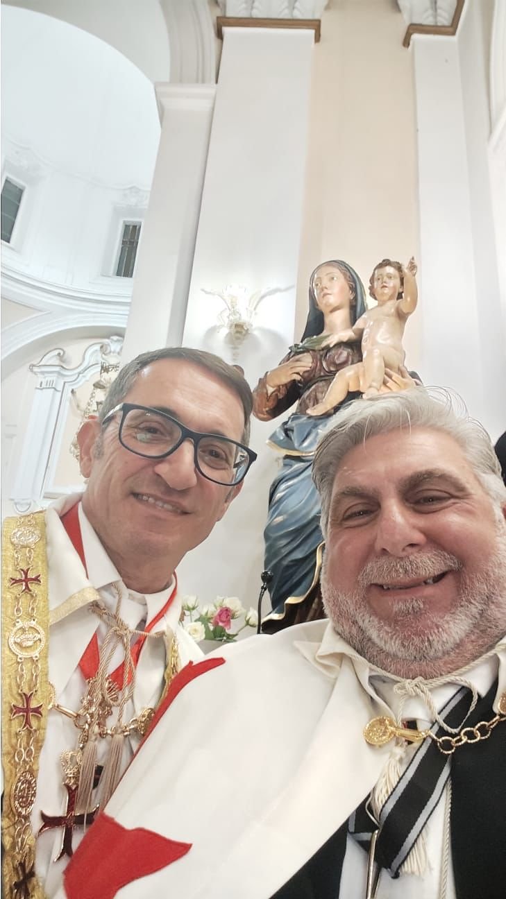 Nuovi investiti in piedi nella navata della chiesa durante il rito
