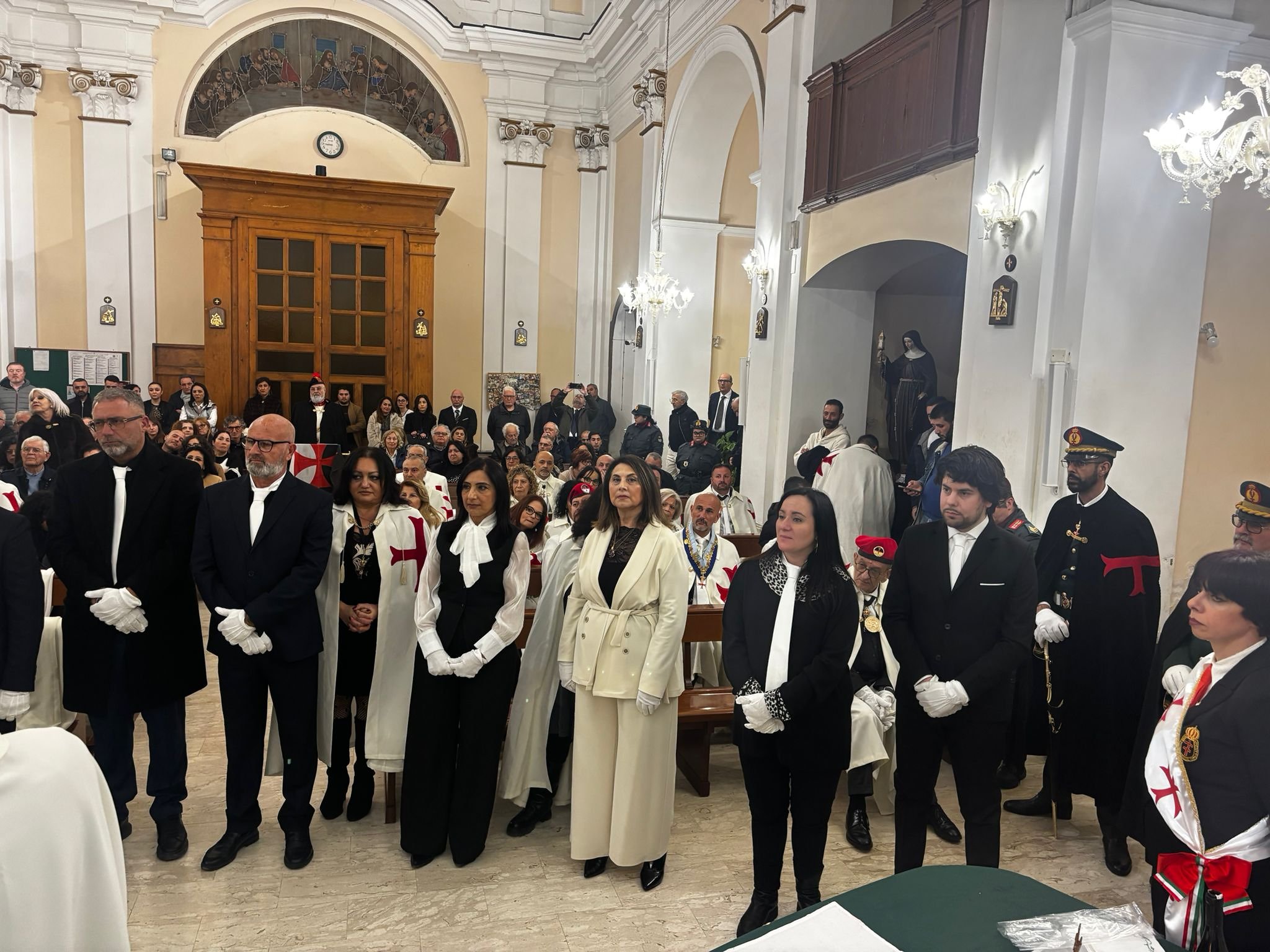Due cavalieri in mantello bianco posano sorridenti in un momento di fratellanza