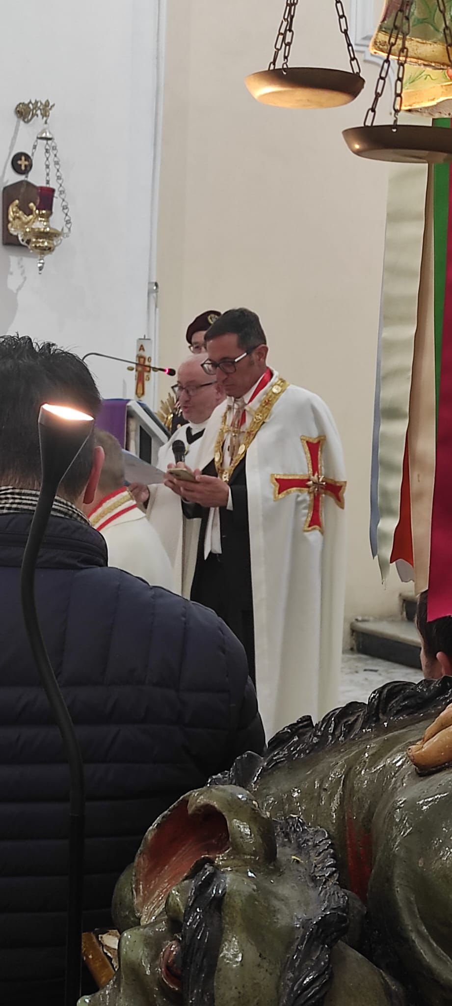 Gran Maestro legge il rito davanti all'altare con la statua di San Michele