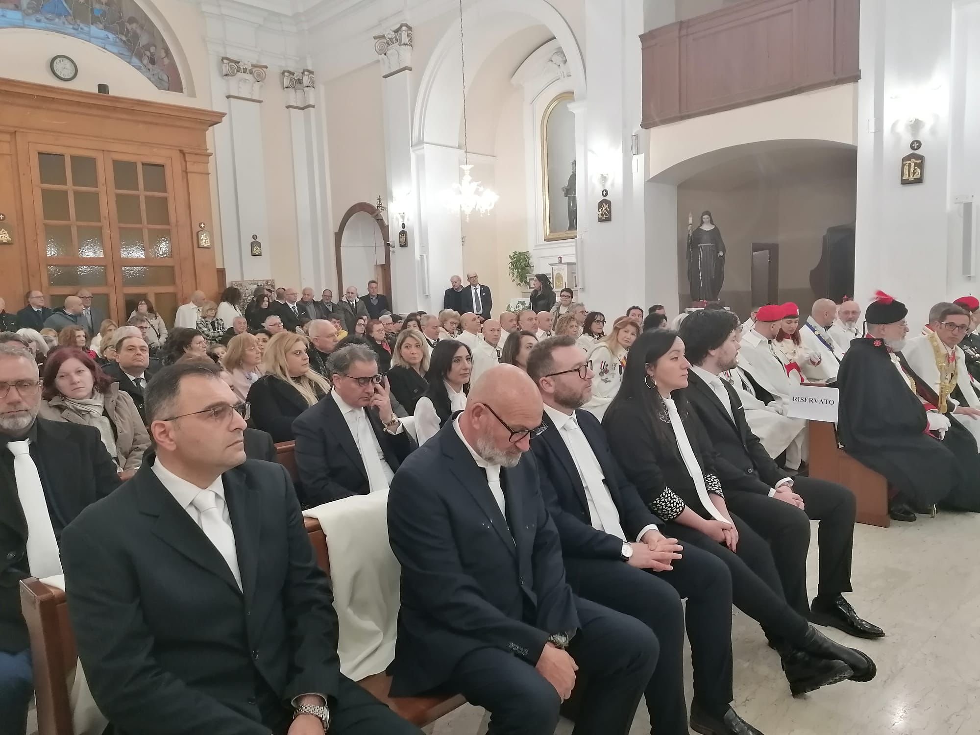 Fedeli e cavalieri riuniti nella chiesa durante la cerimonia templare