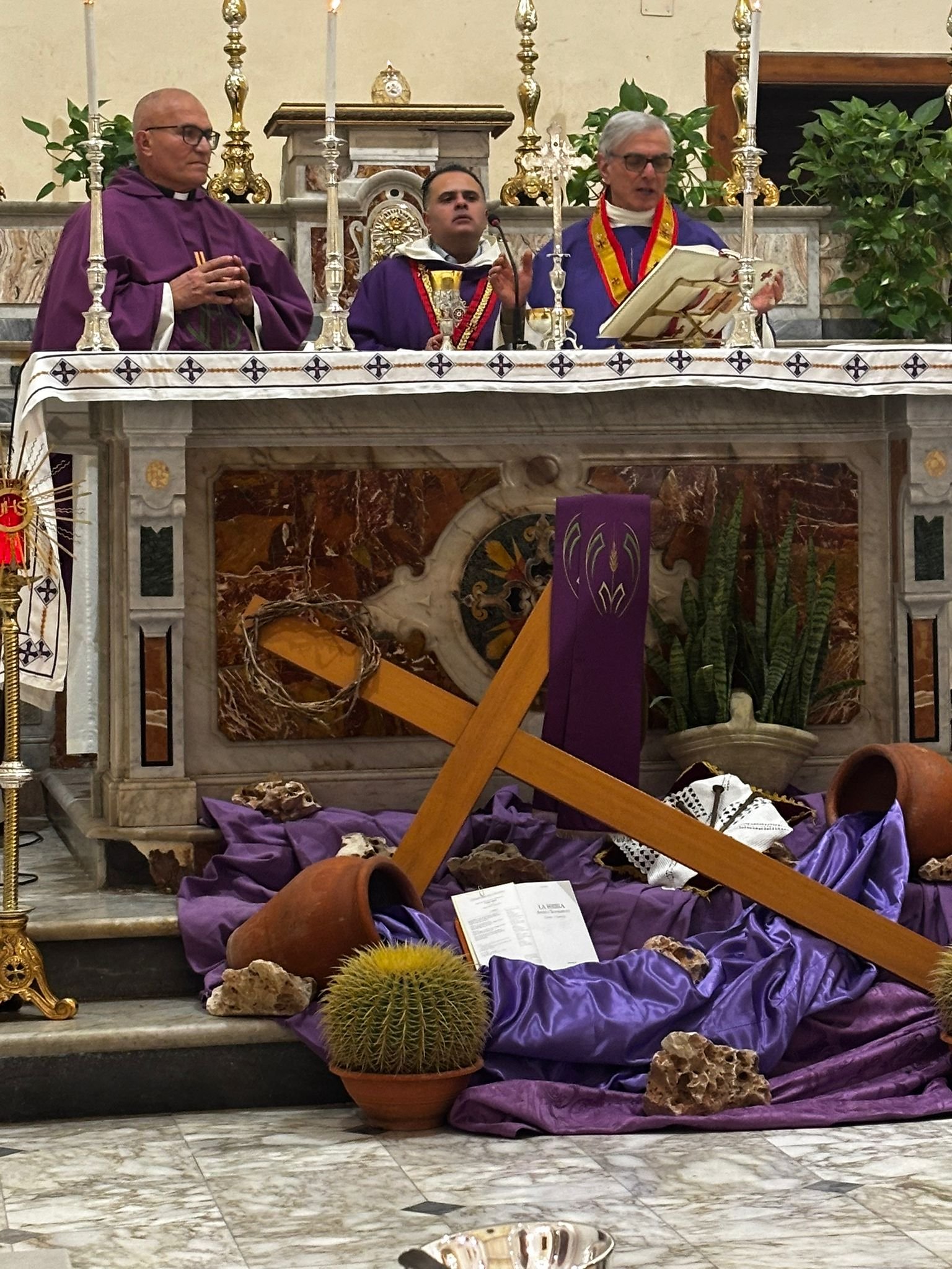 Officianti in veste viola all'altare maggiore durante la messa solenne