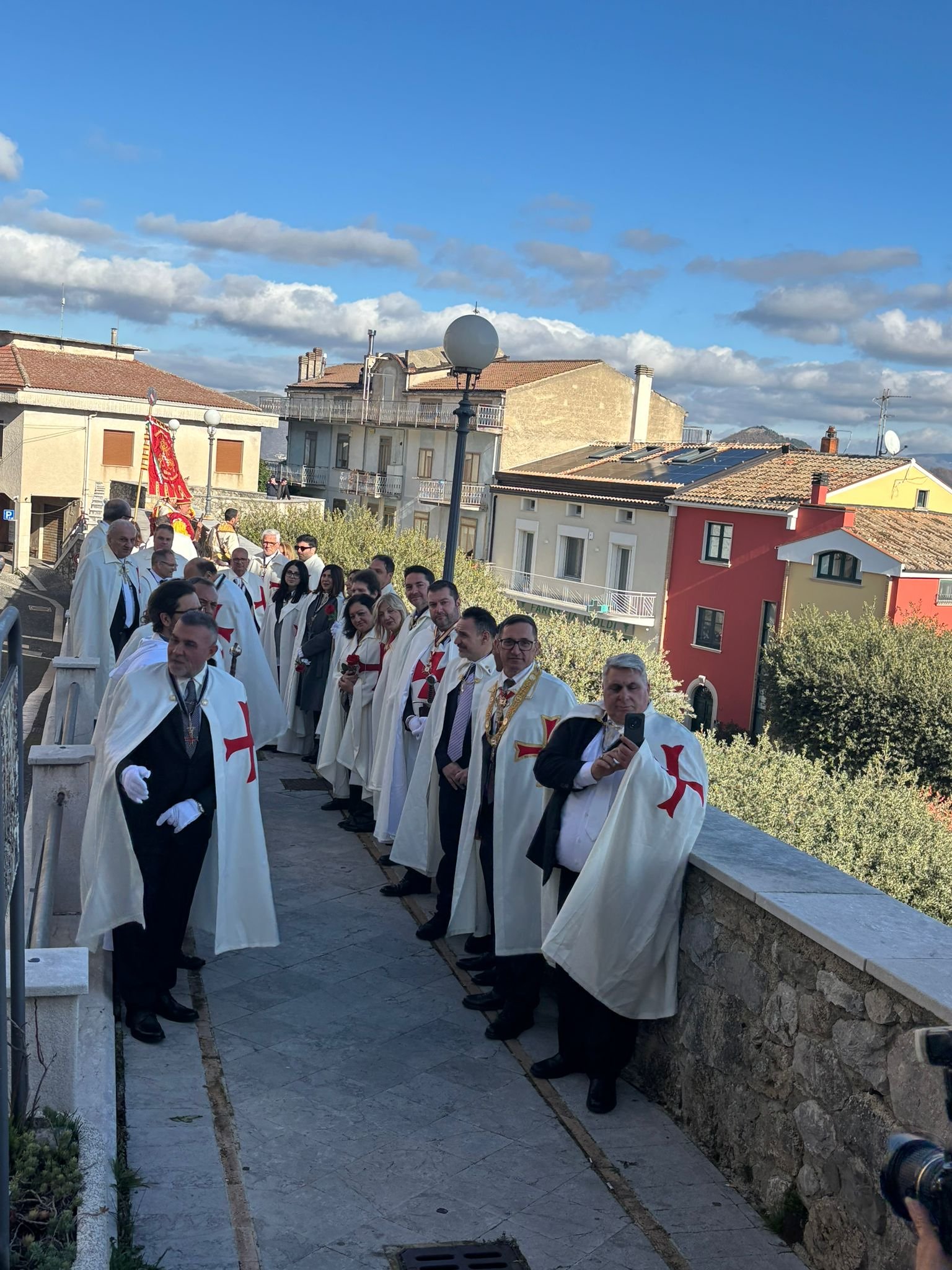 Cavalieri in processione lungo una scalinata del borgo antico