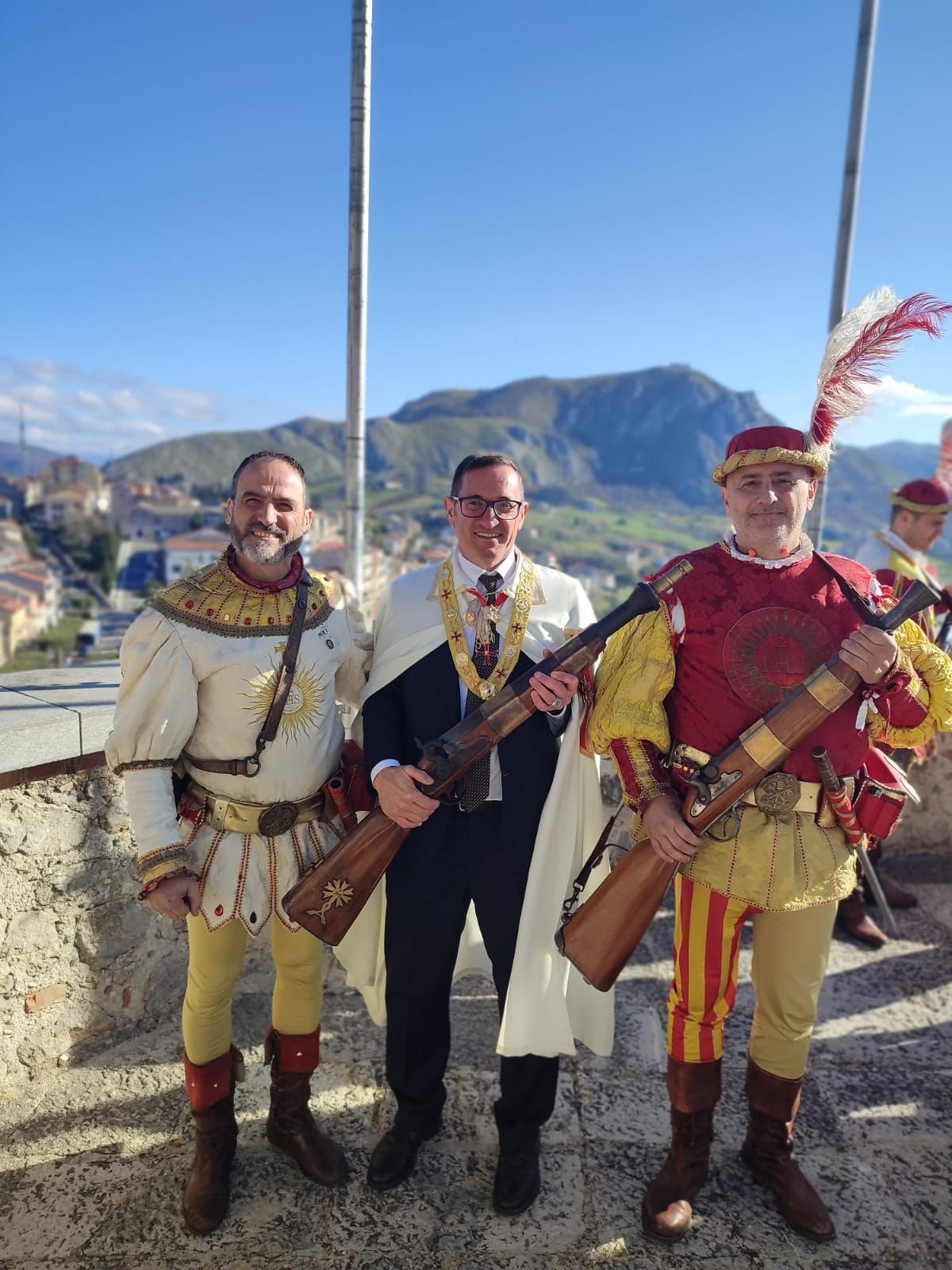Gran Maestro con figuranti storici armati, panorama montano sullo sfondo