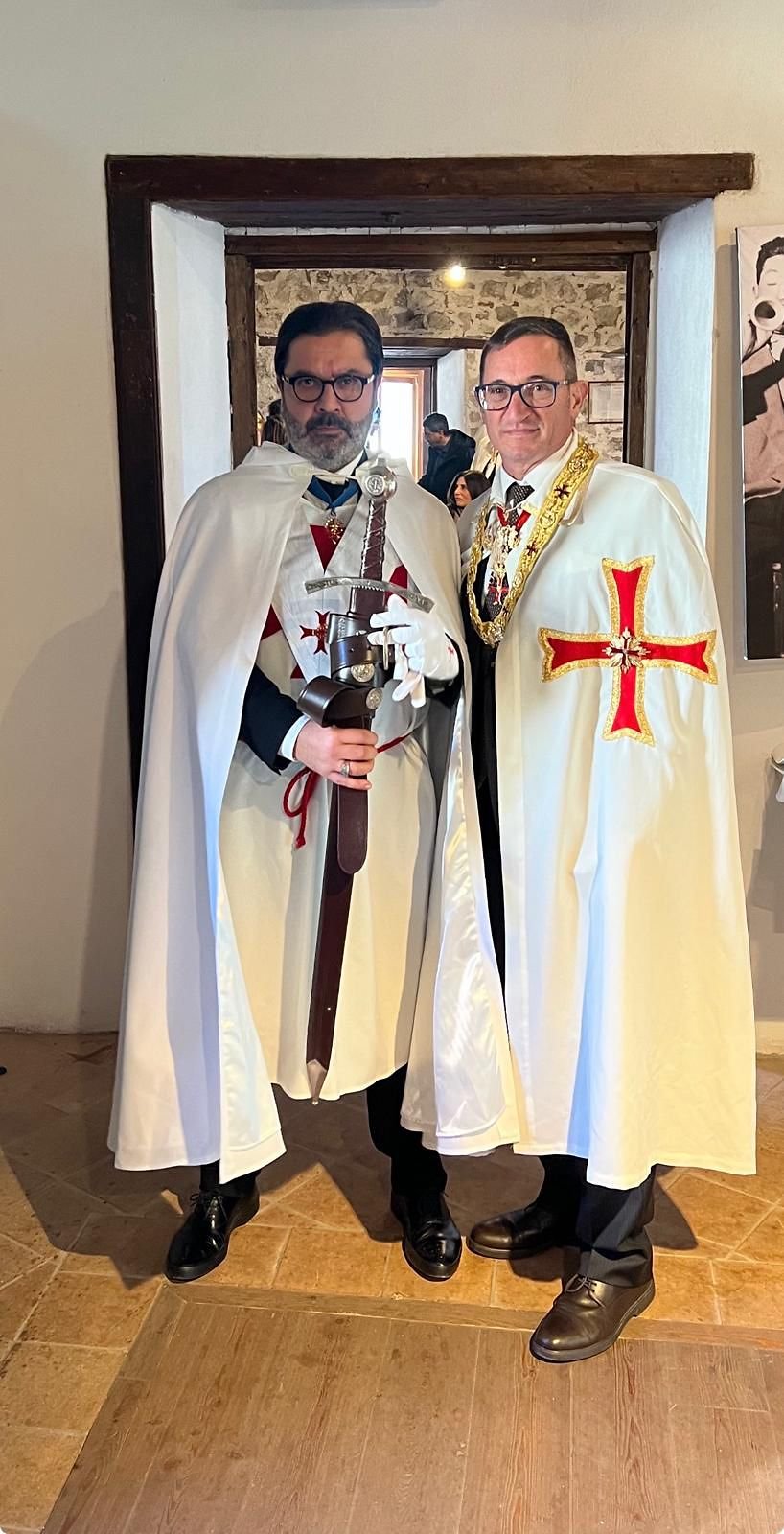 Cavaliere con spada e Gran Maestro posano in un antico edificio templare